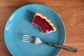 Homemade tasty berry pie half eaten on blue plate