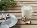 Homemade tasty christmas gingerbread cookies with glass of milk on brown wooden background. Close-up. Branches of a Christmas tree Royalty Free Stock Photo