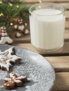 Homemade tasty christmas gingerbread cookies with glass of milk on brown wooden background. Close-up. Branches of a Christmas tree Royalty Free Stock Photo