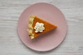 Homemade Thanksgiving pumpkin pie on a pink plate on a white wooden background, overhead view. Top view, from above, flat lay. Royalty Free Stock Photo