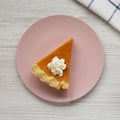 Homemade Thanksgiving pumpkin pie on a pink plate on a white wooden background, top view. Overhead, from above, flat lay. Closeup Royalty Free Stock Photo