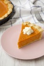 Homemade Thanksgiving pumpkin pie on a pink plate on a white wooden surface, low angle view. Closeup Royalty Free Stock Photo