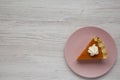 Homemade Thanksgiving pumpkin pie on a pink plate on a white wooden surface, top view. Overhead, from above, flat lay. Copy space Royalty Free Stock Photo