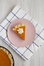 Homemade Thanksgiving pumpkin pie on a pink plate on a white wooden table, top view. Overhead, from above, flat lay Royalty Free Stock Photo