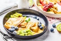 Homemade thin crepes served with curd cream, fruits and berries in black and white plates Royalty Free Stock Photo