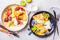 Homemade thin crepes served with curd cream, fruits and berries in black and white plates, top view Royalty Free Stock Photo