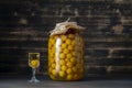 Homemade tincture of yellow cherry plum in glass jar and a wine crystal glass on wooden background, Ukraine, close up Royalty Free Stock Photo