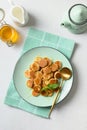 Homemade tiny cereal pancakes on white table. View from above. Copy space