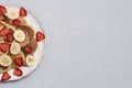 Homemade tiny pancakes on white plate on neutral concrete background