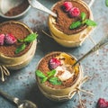 Homemade Tiramisu in individual glasses with raspberries and fresh mint