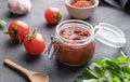 Homemade tomato sauce for pizza or pasta in a jar on a dark background with fresh vegetables, herbs and spicy close up Royalty Free Stock Photo