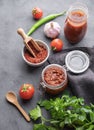 Homemade tomato sauce for pizza or pasta in a jar on a dark background with fresh vegetables, herbs and spicy. The concept of Royalty Free Stock Photo