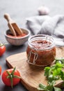 Homemade tomato sauce for pizza or pasta in a jar on a gray background with fresh vegetables, herbs and spicy close up Royalty Free Stock Photo