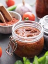 Homemade tomato sauce for pizza or pasta in a jar on a gray background with fresh vegetables, herbs and spicy close up Royalty Free Stock Photo
