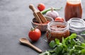 Homemade tomato sauce for pizza or pasta in a jar on a gray background with fresh vegetables, herbs and spicy. The concept of Royalty Free Stock Photo