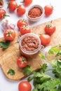 Homemade tomato sauce for pizza or pasta in a jar on a wooden board on a light background with fresh vegetables and herbs close up Royalty Free Stock Photo