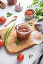 Homemade tomato sauce for pizza or pasta in a jar on a wooden board on a light background with fresh vegetables and herbs Royalty Free Stock Photo