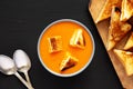 Homemade Tomato Soup with Grilled Cheese Croutons on a black surface, top view. Flat lay, overhead, from above Royalty Free Stock Photo