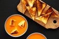 Homemade Tomato Soup with Grilled Cheese Croutons on a black surface, top view. Flat lay, overhead, from above Royalty Free Stock Photo