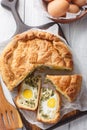 Homemade Torta Pasqualina is a traditional Ligurian Easter pie made with greens, ricotta, egg, and cheese closeup on the wooden