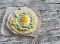 Homemade tortilla with mashed avocado and a fried quail egg.