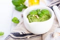 Homemade traditional basil pesto with olive oil, cedar nuts and garlic in a white bowl on a wooden rustic table Royalty Free Stock Photo