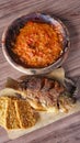 Homemade traditional dish fried fish of Nila with hot sambal chili tomato garlic on wood plate and fried tempeh