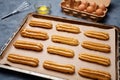 Homemade traditional eclairs or profiterole preparing recipe on baking sheet