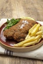 Homemade traditional Milanese veal escalope with french fries