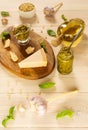 Homemade traditional pesto sauce: basil, olive oil, parmesan, garlic, pine nuts. Ingredients lay on brown wooden board. Royalty Free Stock Photo