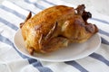 Homemade rotisserie chicken on white plate, side view. Close-up Royalty Free Stock Photo