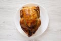 Homemade traditional rotisserie chicken on a white plate, top view. Flat lay, overhead, from above