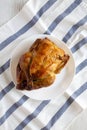 Homemade traditional rotisserie chicken on white plate, top view. Flat lay, overhead, from above