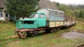 A homemade train with carriages, constructed from a car and a train, stands on the rails, waiting for a ride