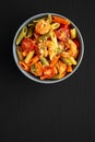 Homemade Tri-Color Penne Salad with Shrimp, Tomato and Basil Bread Crumbs in a Bowl on a black background, top view. Flat lay, Royalty Free Stock Photo