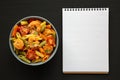 Homemade Tri-Color Penne Salad with Shrimp, Tomato and Basil Bread Crumbs in a Bowl on a black background, top view. Flat lay, Royalty Free Stock Photo