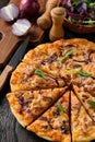 Homemade tuna and mozzarella pizza on wooden background.