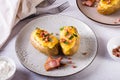 Homemade twice baked potatoes with cheese and bacon on a plate on the table