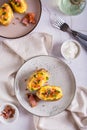 Homemade twice baked potatoes with cheese and bacon on a plate on the table. Top and vertical view