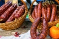 Homemade Ukrainian sausage in baskets on traditional embroidered tablecloth is sale at the market