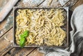 Homemade uncooked Italian pasta in wooden tray over shabby background Royalty Free Stock Photo