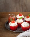 Homemade unsweetened savory appetizer cupcakes snacks with cream cheese frosting, tomato and fresh basil over wooden background, Royalty Free Stock Photo