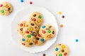 Homemade vanilla cookies decorated with multi-colored candy drops on white background. Top view, close up