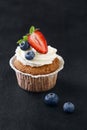 Homemade vanilla cupcake with fresh strawberry and blueberries