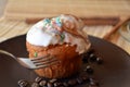 Homemade vanilla muffin with chocolate on a brown plate.