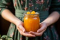 Homemade vegan apricot jam held in gentle hands a jar of pure goodness