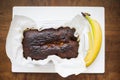 Homemade vegan baked banana bread on parchment paper just on wooden counter table