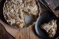 Homemade vegan eggless apple pie in baking form, slice on dark plate