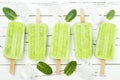 Homemade vegan green tea matcha mint coconut milk popsicles with chia seeds on rustic white wooden background