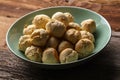 Homemade vegan mini pizza buns made of pizza dough balls filled with garlic butter as side dish, mint green bowl on wooden table Royalty Free Stock Photo